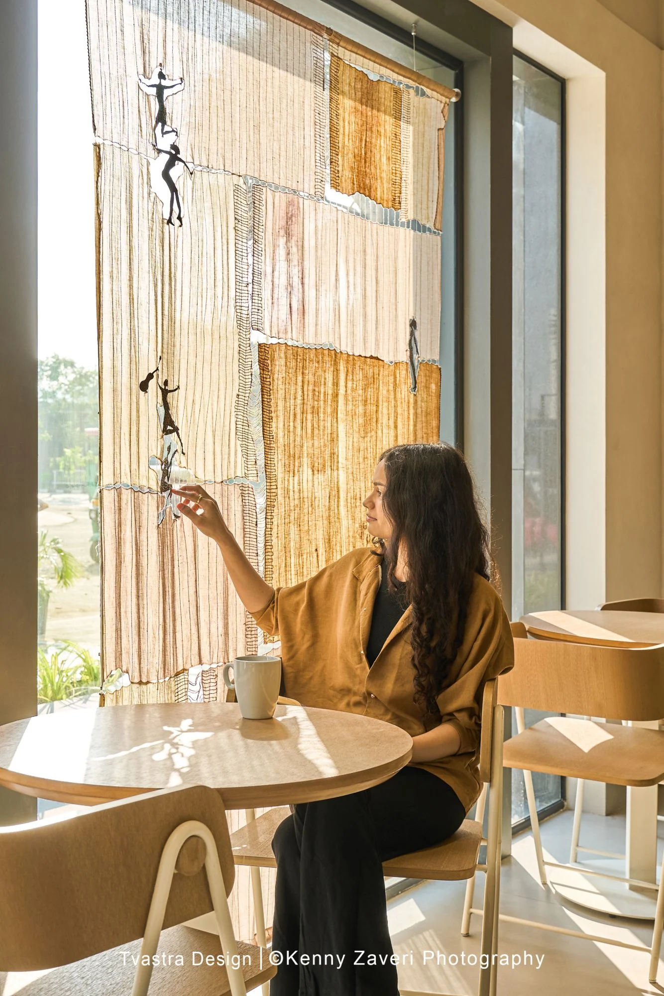 Juneberry, a guest by the window beside an upcycled textile installation